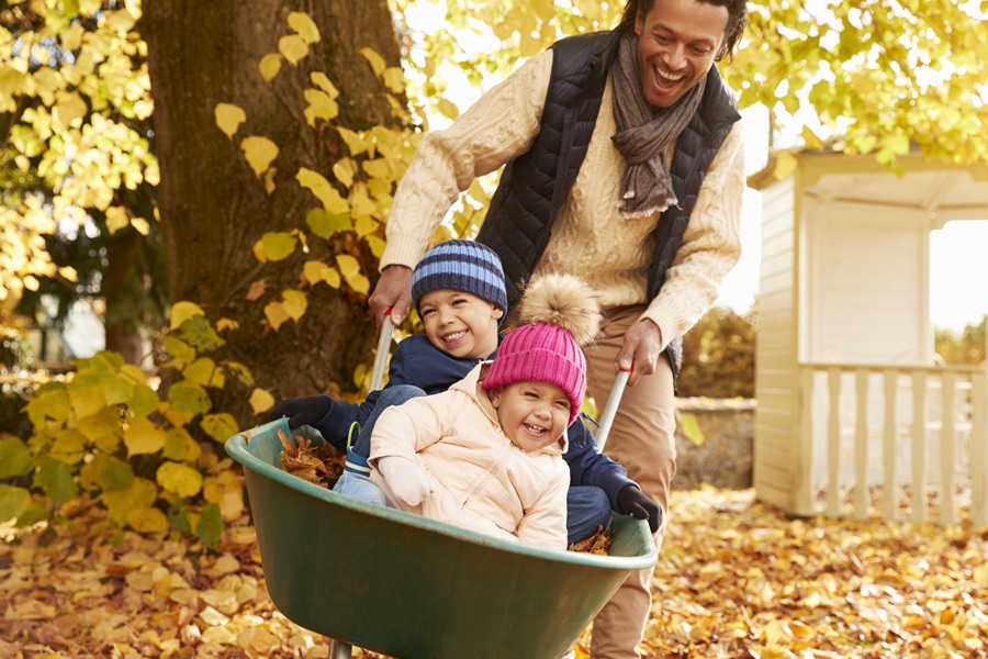 Family playing outdoors enjoying the fall season after scheduling their HVAC maintenance